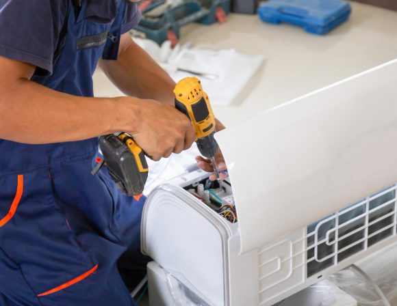 Image pour la page dépannage climatisation présentant une personne réparant un climatiseur